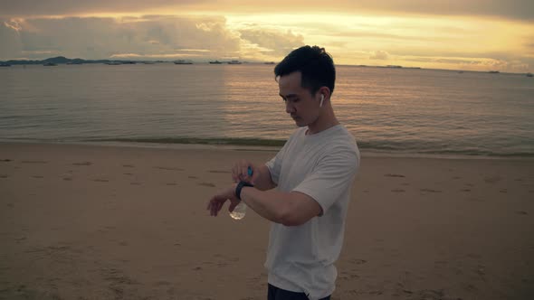 A handsome runner checking heart rate on smartwatch after running.