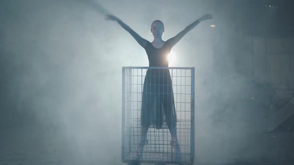 Professional Ballerina Dancing in Black Dress in the Studio in Big Blue Cage in the Black Background