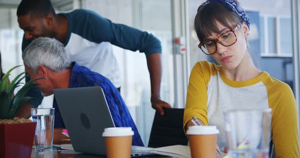 Attentive executive writing in diary while using laptop