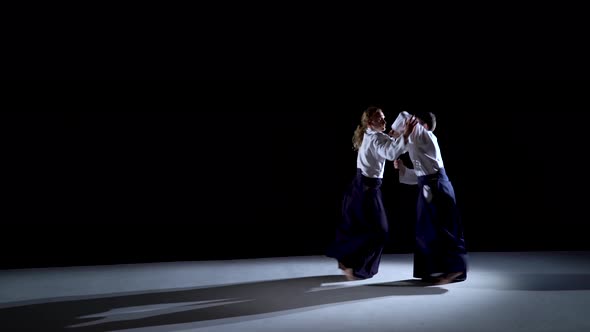 Two Aikido Masters Participants of the Training in Special Clothes of Aikido Hakama Work Out the