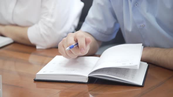 Male Hand Holding Pen. Hand Writing Business Report, Make Note on Paperwork Document on Office Desk