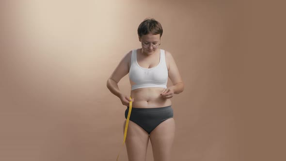 Young Caucasian Woman with Short Haircut in Glasses in Shock After Measuring Her Abdomen