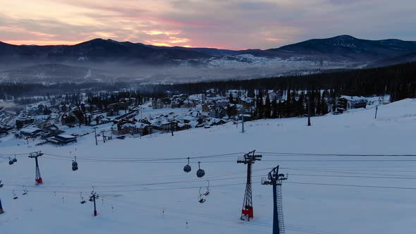 Ski Lift Cabins Move Over Tracks at Dusk Under Evening Sky