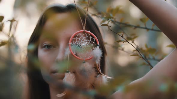 Mysterious Woman Looking Through the Dream Catcher in the Nature