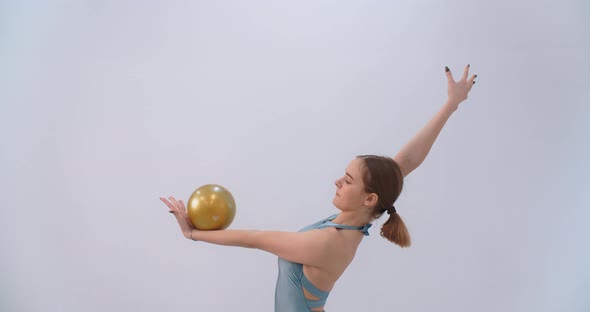 Woman Athlete Performs Callisthenics Exercises with Gymnastic Ball on White Background Sport