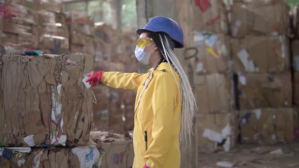 Unloading of Waste Paper in a Warehouse Electric Car Controling By Female Worker in Hard Hat and