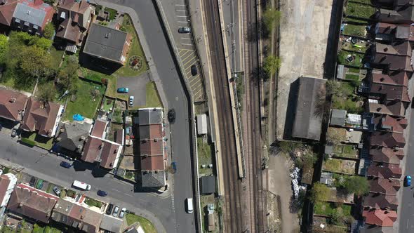 drone shot over railway passing through gentrified suburban london