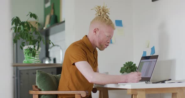 Albino african american man with dreadlocks making video call on the laptop