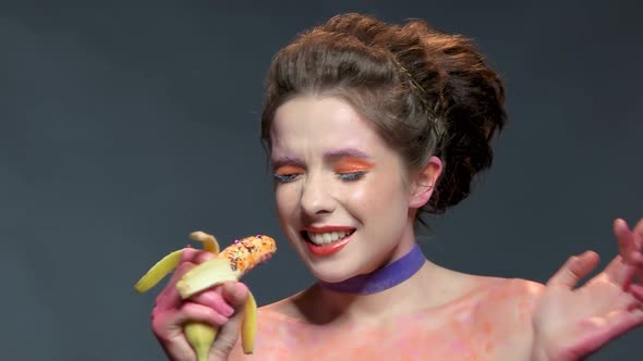 Girl Holding Banana and Smiling.