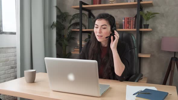 Young Woman Wears Headset Talks To Web Camera Making Distance Online Video Conference. Call Center