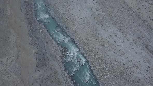 Turquoise River Flowing Through Skardu Valley Floor. Aerial Tilt Up Reveal