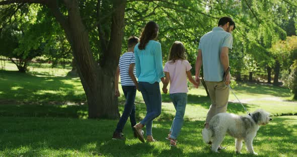 Family walking with their dog in the park on a sunny day