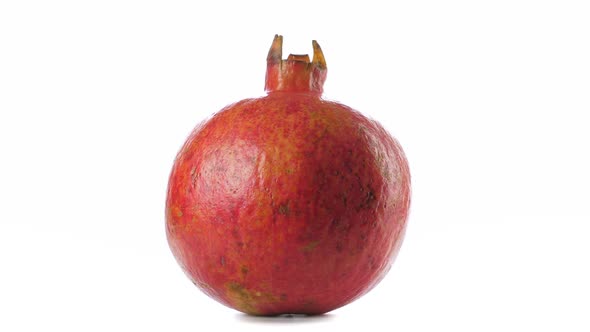 One Red Ripe Whole Pomegranate. Closeup on White Background