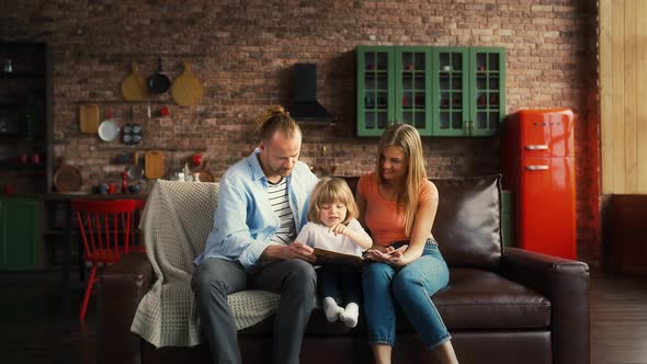 Couple and Child Boy are Sitting on Couch in Studio Apartment