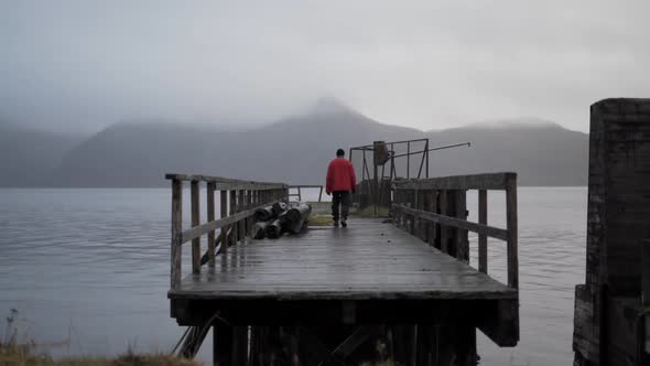 Hiker On Old Pier In Fjord