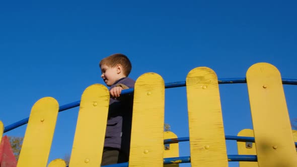 A Boy of 4 Years Old Plays on the Playground in the Castle Against the Sky