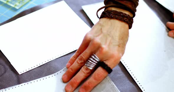 Craftswoman arranging leather piece on work tool