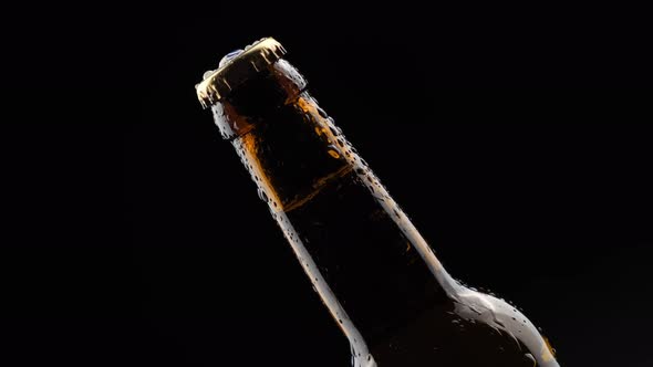 Glass Bottle of Beer Spinning in the Dark on a Black Background