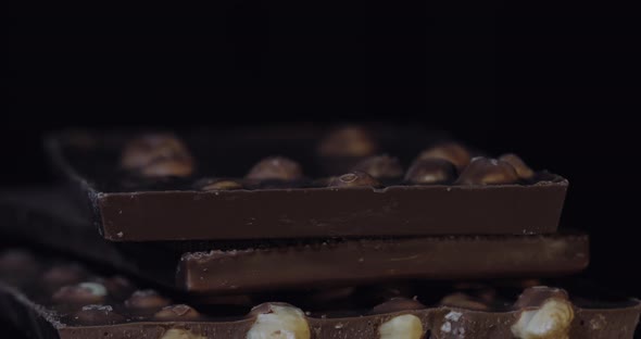 Dark Chocolate Blocks with Nuts Details Slow Close-up Macro. Chocolate Bars