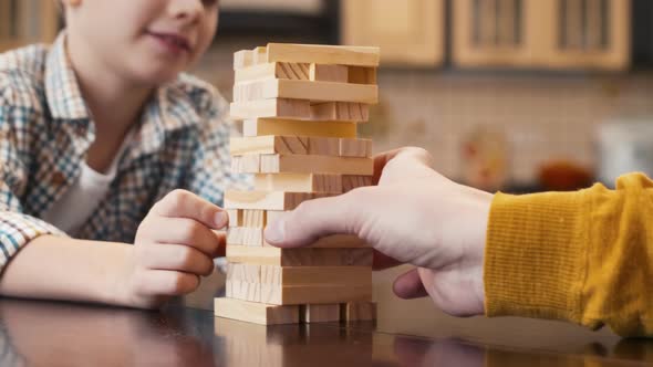 Caucasian boy looking after his Jenga competitor's move