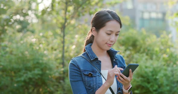 Woman use of mobile phone in city park