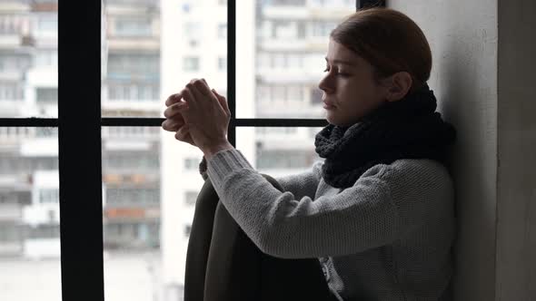 Young woman looks depressive against blurred cityscape background