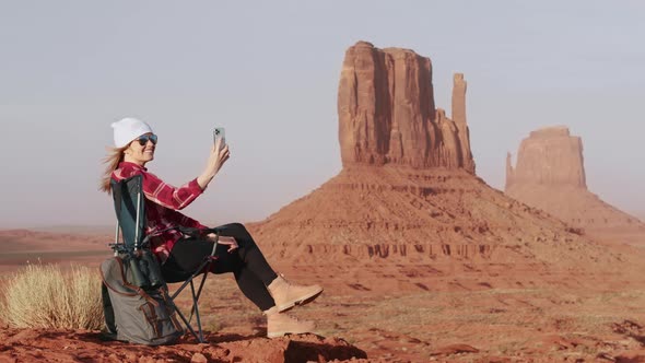 Woman Hiker Backpack Traveler Looking at Smartphone Red Cliffs on Background