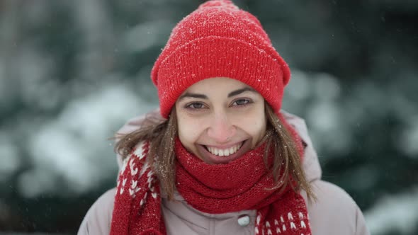 Close Up Face of Happy Attractive Smiling Woman in Red Beanie and Scarf Walking in Park at Winter