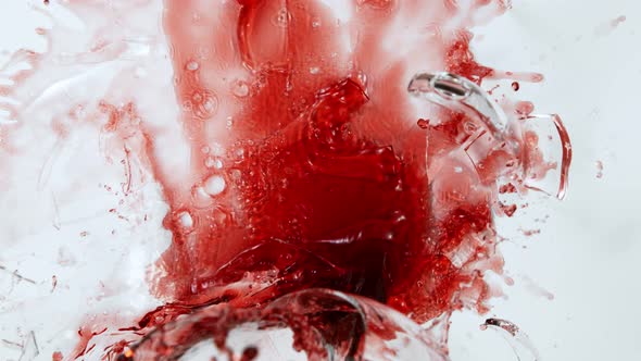 Super Slow Motion Top Shot of Breaking Glass with Red Wine on White Cloth at 1000Fps.