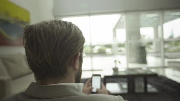 Man text messaging with smartphone in waiting room