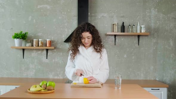 Woman Waking Up in Morning and Cut Lemon and Putting It in Water Glass