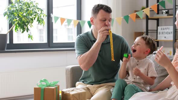 Happy Family with Gifts and Party Blowers at Home