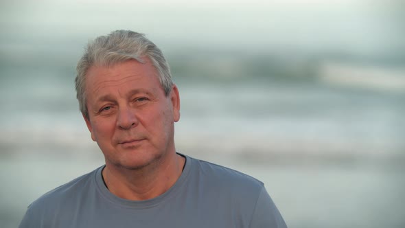 Senior Man with a Slight Smile Portrait Against the Sea
