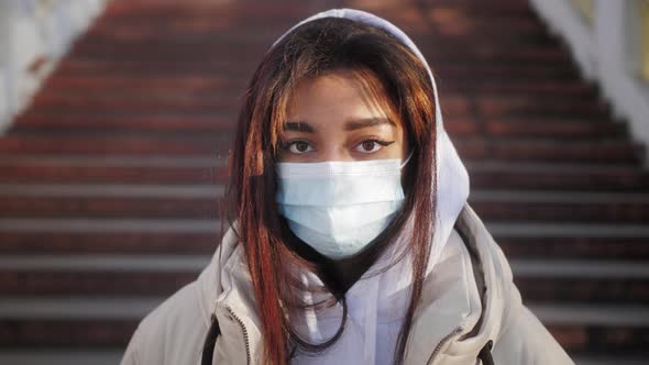 Portrait of Beautiful Black Young Woman Wearing Protective Medical Face Mask and Standing on the