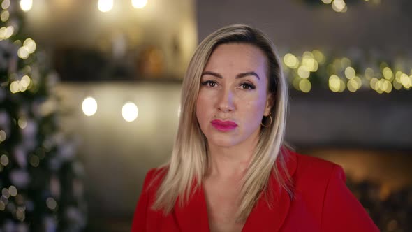 Portrait of a Blonde in a Red Blazer on the Background of a Living Room Decorated for Christmas