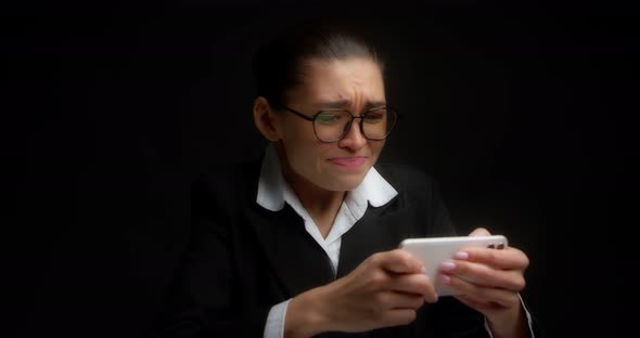 Gambling Business Woman Enthusiastically Plays a Game on a Cell Phone