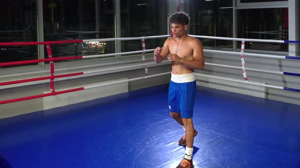 Hispanic Boxer Doing Somersault in Boxing Gym
