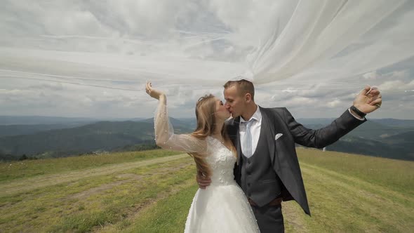 Groom with Bride Having Fun on a Mountain Hills. Wedding Couple. Happy Family