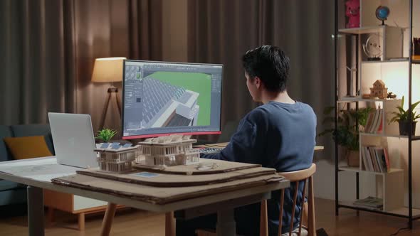 Asian Male Engineer Zoom In 3D House While Working On A Desktop At Home