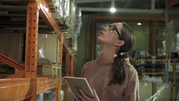 Closeup of a Young Employee with a Computer Tablet Working in the Warehouse