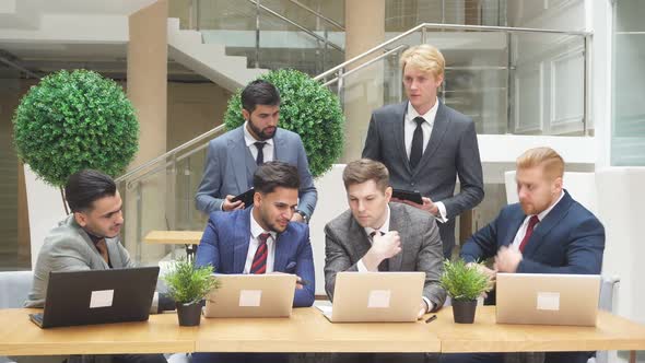 Group of Multi National Young Men Looking at Laptop While Discussing New Project, New Deal.