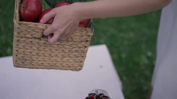 Closeup Female Hands Putting Vegetable Basket on Table Outdoors in Slow Motion