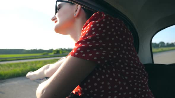 Profile of Young Girl with Scarf in Her Hand Leaning Out of Window Vintage Car and Enjoying Ride in