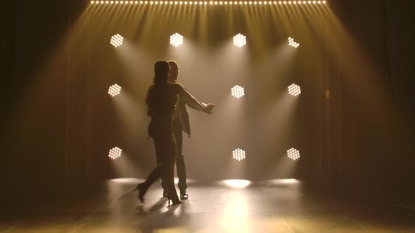 Young Couple Dancing Latin Music. Bachata, Merengue, Salsa. Shot in a Dark Studio with Neon Lights