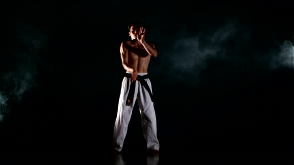 Karate or Taekwondo Man with a Naked Torso and a Black Belt, Smoke