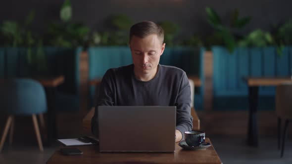 Beautiful Male Developer or Student Working Studying By Laptop in Cafe