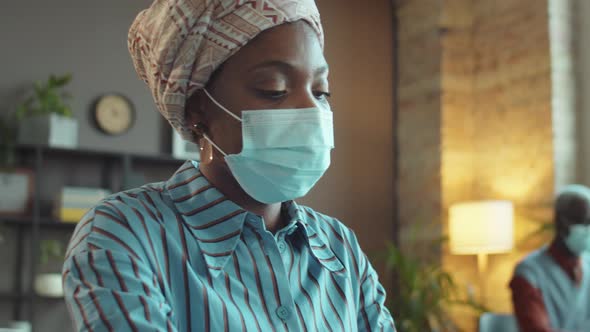 Black Woman in Mask Working in Office during Covid Pandemic