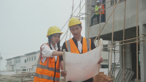 Group team of engineer and architect looking blueprint and explaining using radio communication.