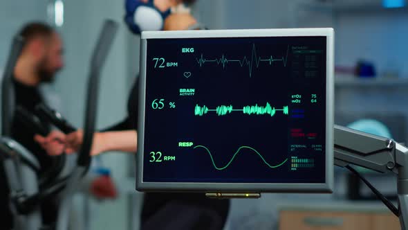 Monitor Showing EKG Scan of Athlete Running on Cross Trainer