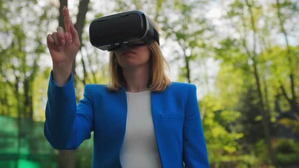 Business Woman Controls the Virtual Interface By Pressing Buttons with Her Finger in VR Goggles